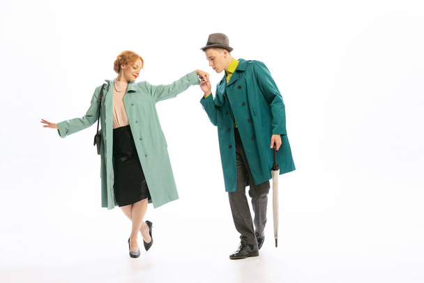 Stylish couple, man and woman in beautiful coats posing isolated over white background. Lady and gentleman. Concept of retro fashion, style, youth culture, emotions, beauty. Copy space for ad - Foto, immagini