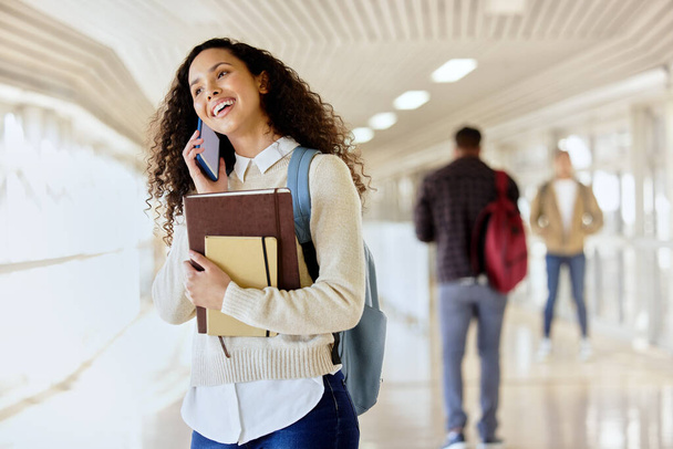 Wanna meet up during lunch. an attractive young female student making a call while standing in a campus hallway - Foto, Imagen