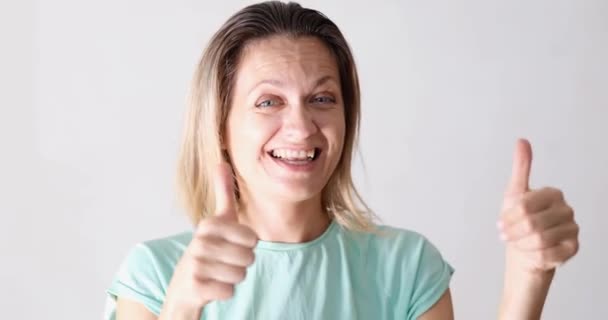 Laughing woman showing thumbs up, close-up. Joyful emotions, positive feelings, facial expressions and gestures - Кадры, видео