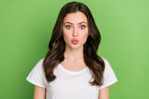 Photo of cute impressed young lady wear white t-shirt lips pouted isolated green color background. - Foto, Imagen