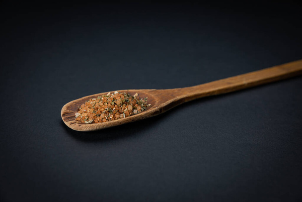 spoon of dried coriander seeds on a black background - Foto, afbeelding