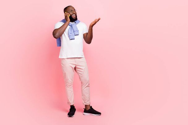 Full size image of young positive guy waiting for his girlfriend date talking with friend on phone isolated on pink color background. - Foto, afbeelding