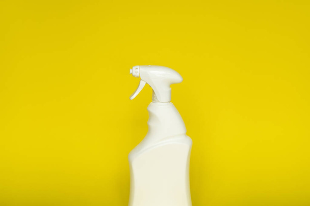 Sarı arka planda izole edilmiş sıvı temizlik ürünleri için beyaz plastik sprey şişesi. Püskürtücüyle paketleme şişesi - Fotoğraf, Görsel
