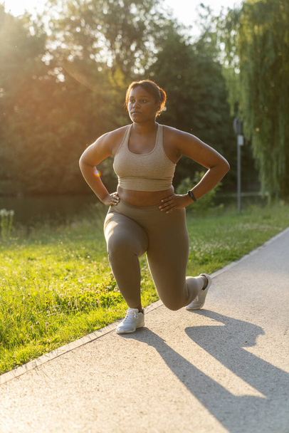 Plus sized African American woman exercising at the park in a  summer day  - Foto, Bild