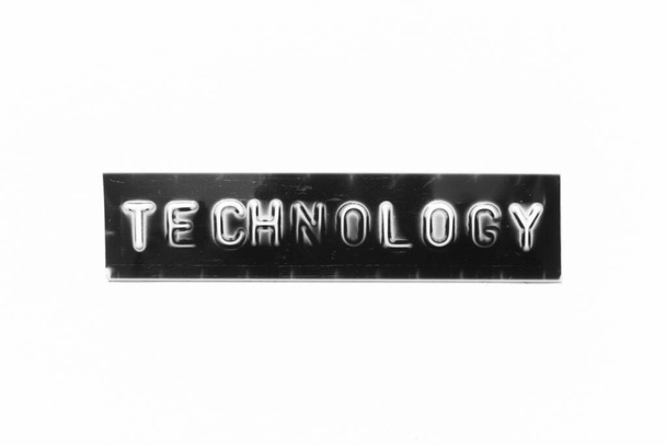 Embossed letter met woord technologie in zwarte banner op witte papieren achtergrond - Foto, afbeelding
