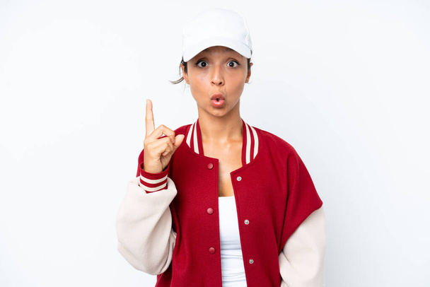 Young hispanic woman wearing a baseball uniform isolated on white background intending to realizes the solution while lifting a finger up - Fotó, kép