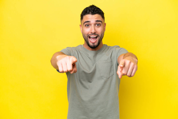 Young Arab handsome man isolated on yellow background surprised and pointing front - Foto, Bild