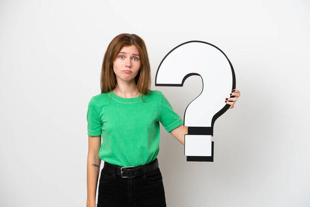 Young English woman isolated on white background holding a question mark icon and with sad expression - Фото, зображення