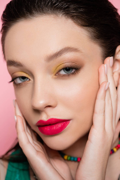 close up of young model with bright makeup looking at camera isolated on pink  - Foto, Imagen