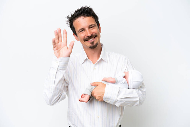 Young man with his newborn baby saluting with hand with happy expression - Foto, Bild