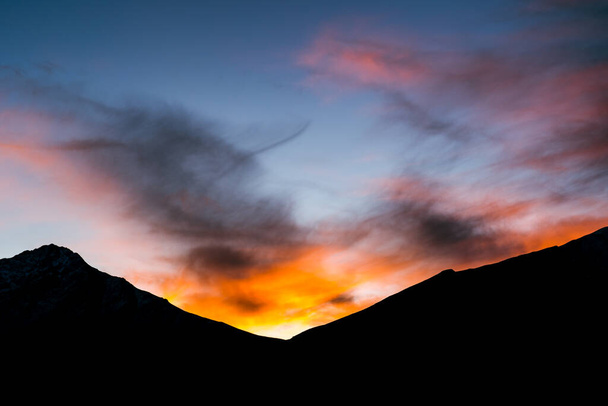 A silhouette of a mountainous range at sunset - Fotó, kép
