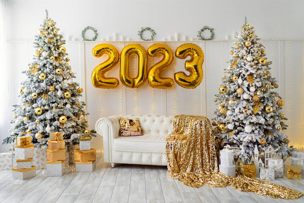 White room interior with New Year tree decorated, present boxes and white sofa. Colden colors . - Foto, Imagem