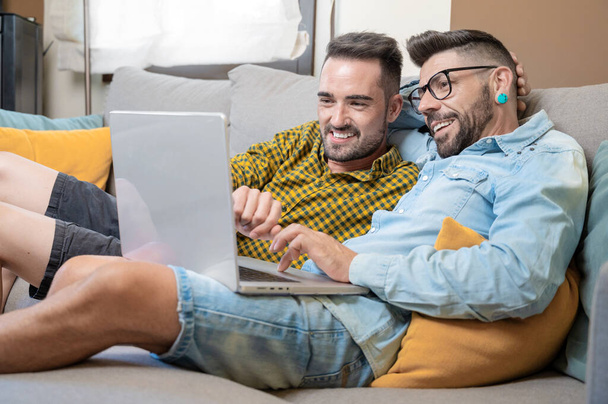 Male caucasian gay couple using laptop computer at home. High quality photography. - Foto, immagini