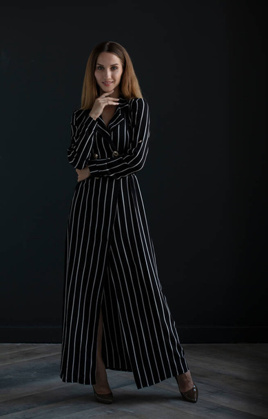 portrait of beautiful young woman in black dress on dark background - Valokuva, kuva