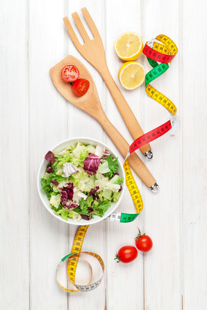frischer gesunder Salat und Maßband - Foto, Bild