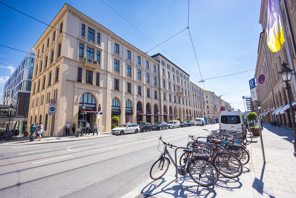 Мюнхен, Німеччина - 6 липня 2022: Cityscape into the Maximilianstrasse, один з чотирьох королівських проспектів. Максиміліанштрассе має найвищу роздрібну орендну плату в Німеччині. Парковка на велосипеді на тротуарі. - Фото, зображення