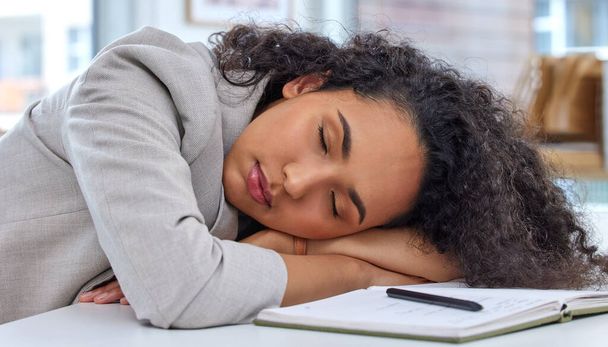 Its difficult to keep up when youre low on energy. a young businesswoman sleeping at her desk in an office - Foto, afbeelding