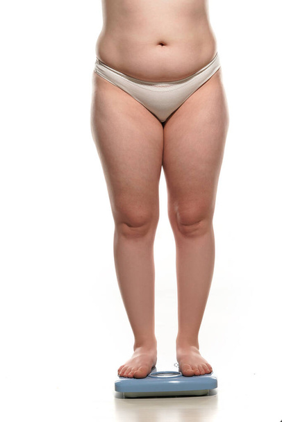 obesity and overweight, overweight woman legs and belly on the scale, concept of obesity. - Photo, image