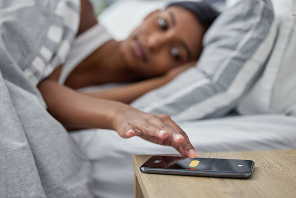 Its time to wake up. a womans alarm on her cellphone going off while she lies in bed - Fotoğraf, Görsel