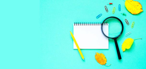 School stationery and white notebook on green background. The concept of back to school or Teachers day. Creative copy space for seasonal projects and basis designs. Close-up - 写真・画像
