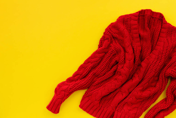 Womens red sweater on yellow background. Flat lay top view shopping sale fashion mock up. - 写真・画像