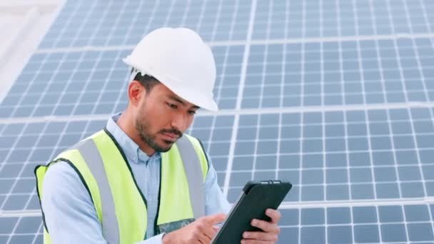 Solar power installation, environmental panels and setup being done by engineer while using a tablet for planning. Portrait of one young and cheerful technician smiling while browsing on technology. - Filmagem, Vídeo