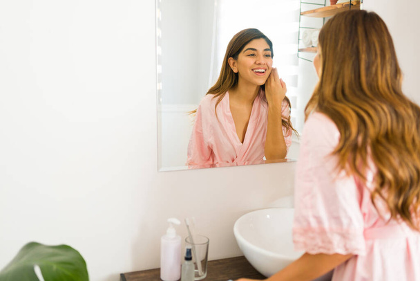 Cheerful young woman smiling while feeling satisfied and happy with her skin care routine  - Photo, image