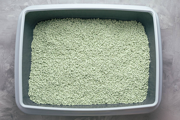 Kissan hiekkalaatikko, jossa on luonnollinen huuhtoutuva biohajoava tofu-pentue, jossa on vihreän teen jauheen tuoksu. Ympäristöystävällinen tuote sisätiloissa lemmikkieläimiä. Top näkymä, kopioi tilaa - Valokuva, kuva