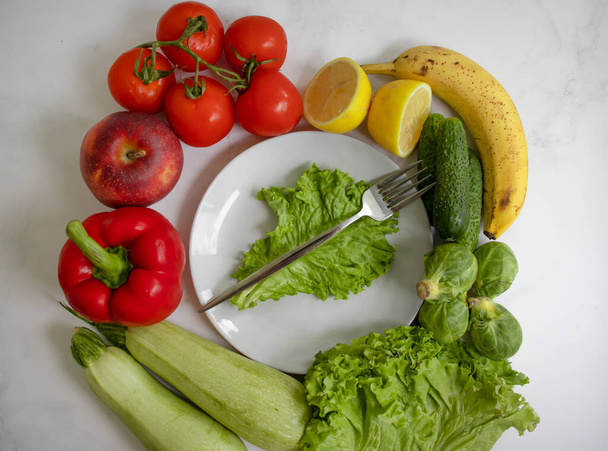 Тарілка з різних овочів і фруктів на світлому фоні
 - Фото, зображення