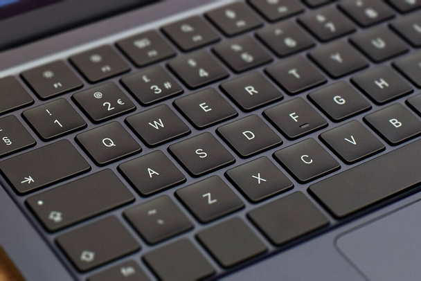 Modern, slim, backlit laptop membrane keyboard. Black keyboard large board. Selective focus. close-up of laptop keys. - Фото, изображение