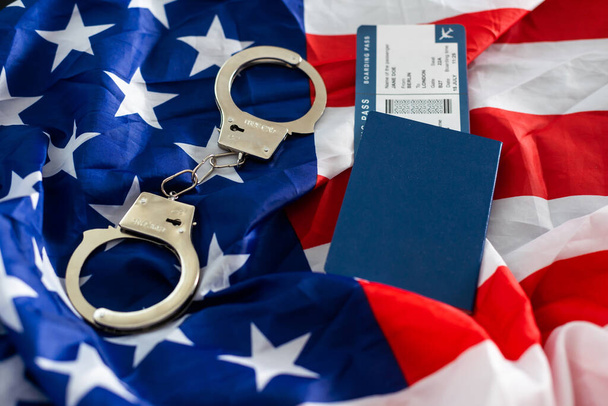 International passport with handcuffs on USA flag background. - Foto, Imagem