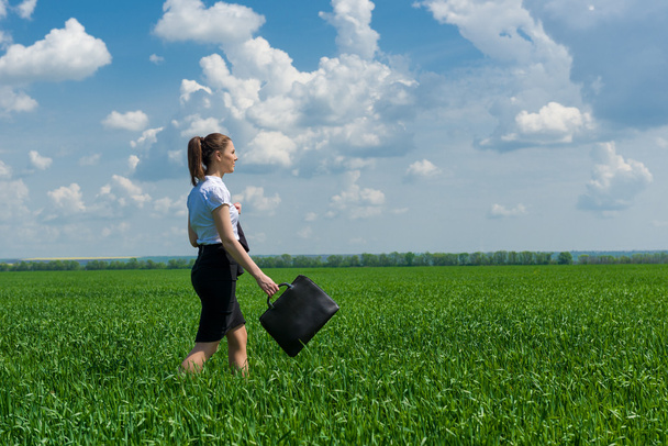meisje met een werkmap lopen op het gras - Foto, afbeelding