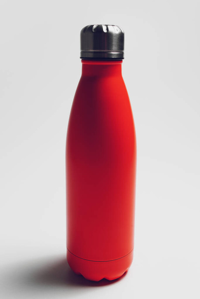 Close-up of reusable eco water bottle of red on white studio background. - Foto, imagen