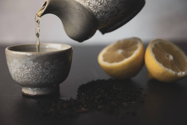 Pouring Korean tea into teacups with lemon and loose leaf tea. High quality photo - Fotó, kép