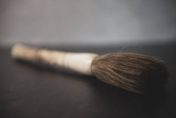 Chinese hand carved bone paintbrush on grey and black background. High quality photo - Foto, imagen