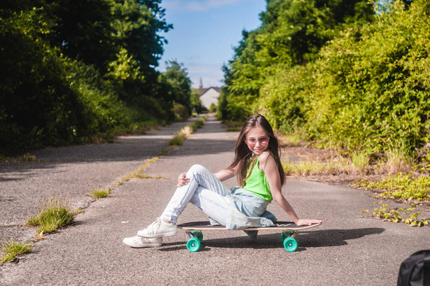 young girl with her skateboard on a sunny day in the park - Fotografie, Obrázek
