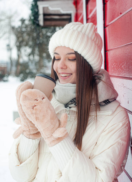 Усміхнена молода жінка п'є каву в засніженому лісі. Зимові канікули
. - Фото, зображення