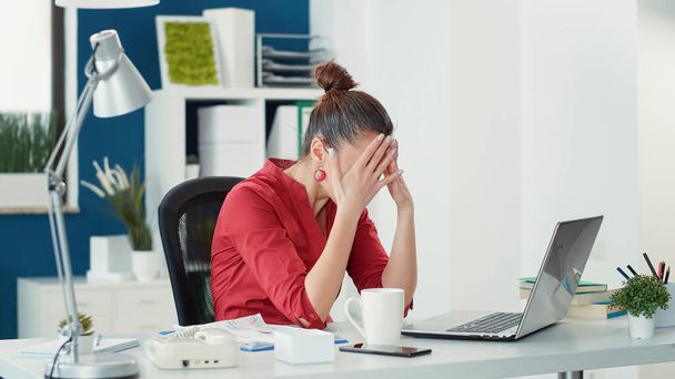 Stressed employee making mistake at office startup job, using sales statistics to do data research. Disappointed woman feeling displeased with business company failure, working on laptop. - Foto, imagen