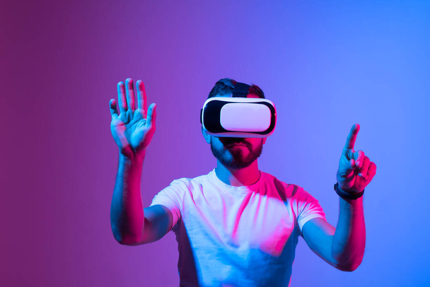 Homem usando óculos de realidade virtual. Conceito de tecnologia VR. Realidade aumentada, futuro conceito de tecnologia. RV. Luz de néon - Foto, Imagem