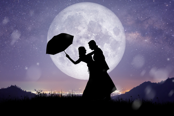 Silhouette in der Nacht Landschaft von Paar oder Liebhaber tanzen und singen auf dem Berg mit Milchstraßenhintergrund über dem Vollmond. - Foto, Bild