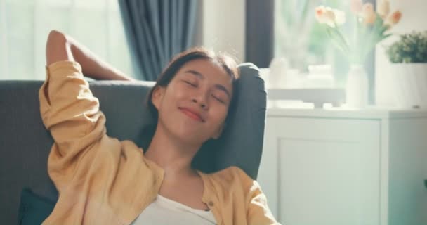 Close-up Youth asia female girl or university student sit on sofa chair take a rest relax feel chill and calm after finish work in living room at house. Environment at home, Work life balance concept. - Video, Çekim