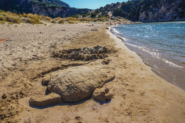 Close-up of a handmade sand sculpture of a Sea turtle at Voidokoilia beach reminds the Sea Turtle Protection in Romanos area in Messenia, Peloponnese, Greece, Europe - Photo, Image
