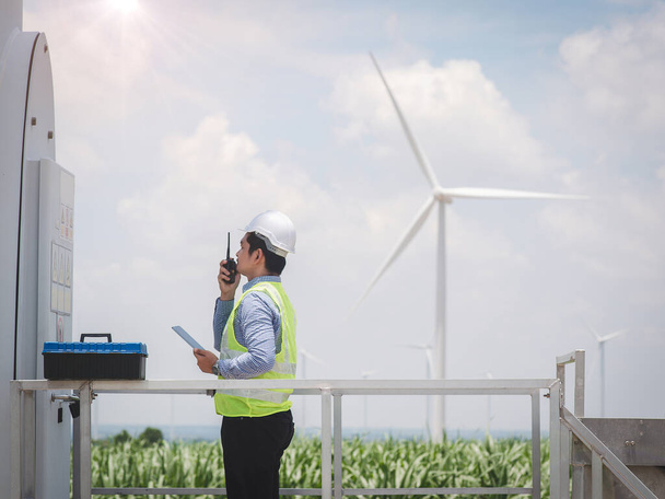 Engineer man is using a tablet to control and monitor the operation of a wind turbine in the electrical control room.Concept of sustainability development by alternative energy - Φωτογραφία, εικόνα