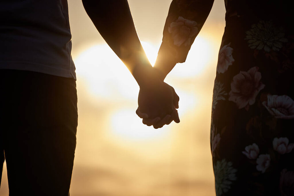 Youre the closest to heaven, that Ill ever be. an unrecognizable couple holding hands while watching the sunset - Foto, imagen