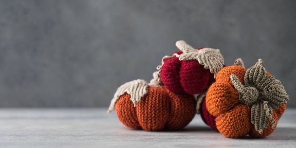  Knitted handmade pumpkins on a grey background. The concept of autumn and coziness. DIY decor. Copy space. - Foto, immagini