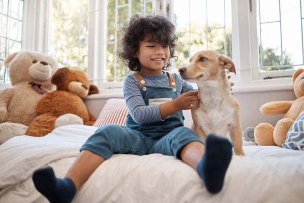 Hänen onnensa tekee kurjista päivistä sen arvoisia. suloinen nuori poika leikkii koiransa kanssa makuuhuoneessaan kotona - Valokuva, kuva