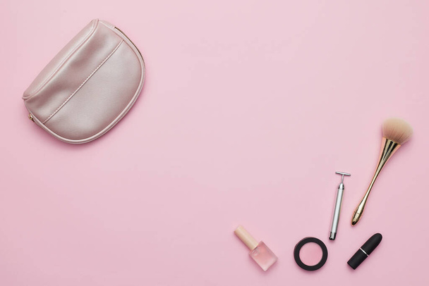 A purse and makeup tools isolated on a pink background - Φωτογραφία, εικόνα