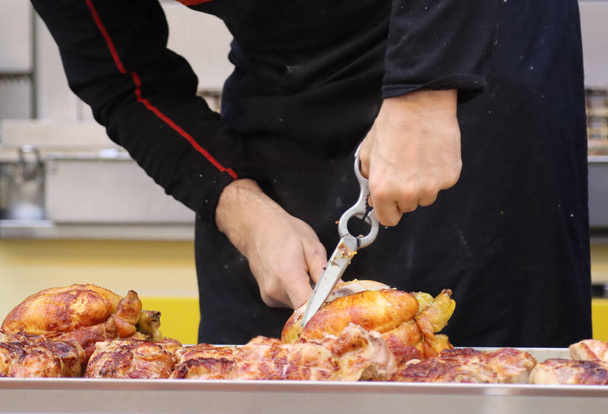A chef cutting the chicken to make barbecue at the local restaurant - Fotoğraf, Görsel