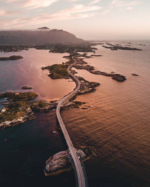 vertical shot of long road going through small islands in ocean - Фото, изображение
