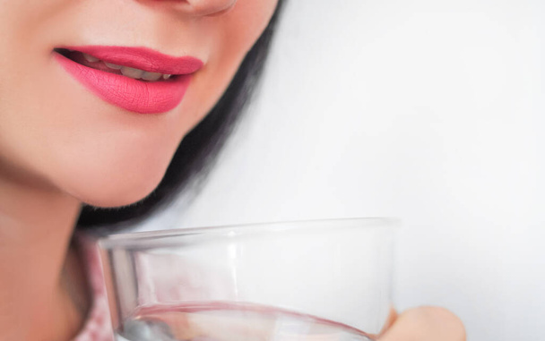 Zblízka mladá žena pije sklenici čisté nehybné vody. Kvalitní fotografie - Fotografie, Obrázek